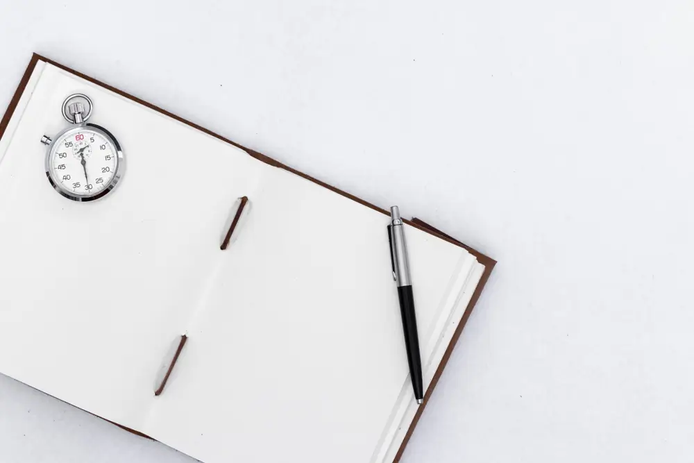 Chronomètre et stylo sur un carnet d'examen ouvert pour évaluer la vitesse lors d'un test psychotechnique.
