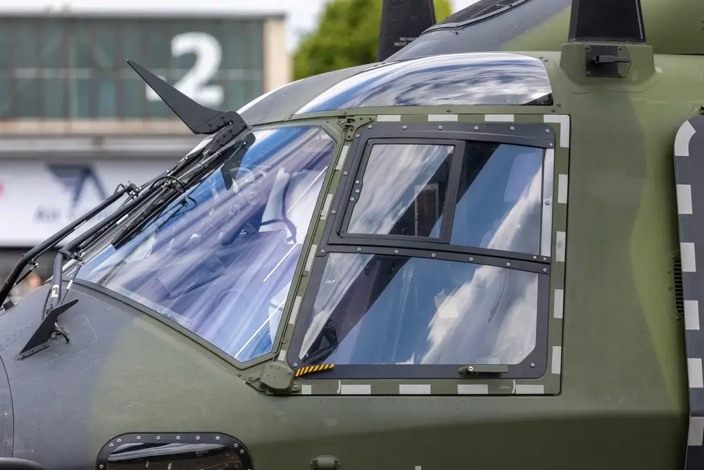 Cockpit d'un hélicoptère militaire camouflage, illustrant la modernisation de la flotte de la Force aérienne.