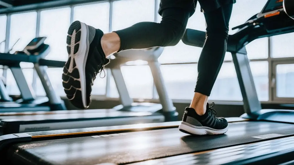 Jambes d'un coureur sur un tapis de course en salle lors d'un test d'endurance pour l'épreuve du PhEF.