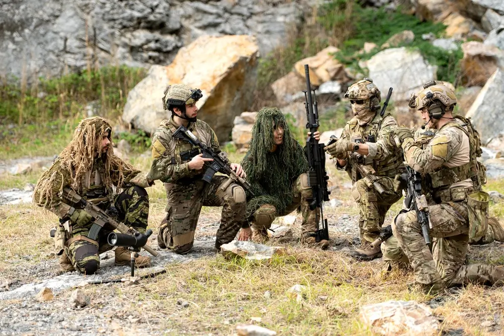 Soldats de l'armée belge en tenue de camouflage lors d'un exercice tactique d'entraînement militaire.